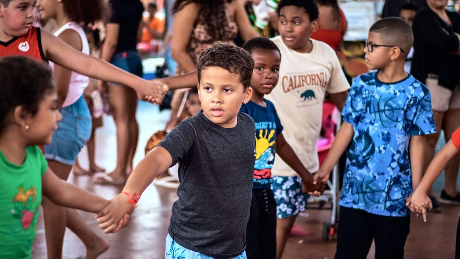 Crianças de mãos dadas formam uma roda numa brincadeira coletiva, no Dia das Crianças da Ilha da Conceição.